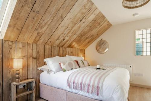 a bedroom with a large bed with a wooden ceiling at The Barn at Thorpewood in Thorpe Market