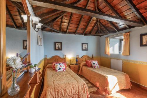 a bedroom with two beds and a wooden ceiling at Casa Asuncion in Breña Alta