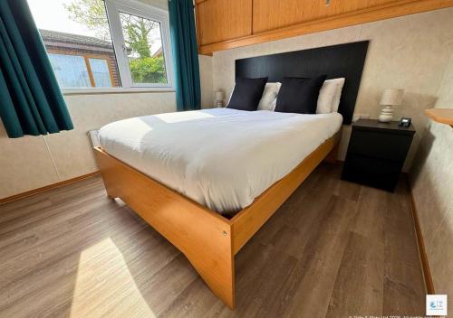 a bedroom with a large bed with a wooden headboard at Rupert's Lodge in West Down