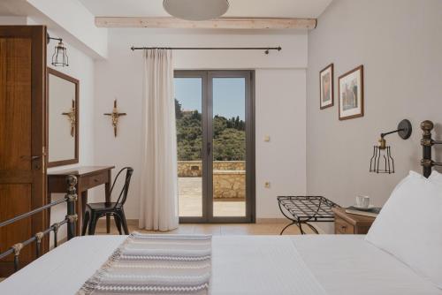 a bedroom with a bed and a desk and a window at Niriides Luxury Apartments in Syvota