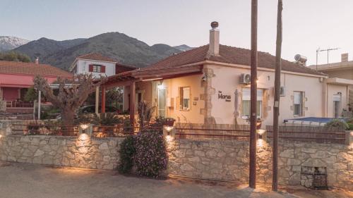 a house with a stone fence in front of it at The Morus House with Private pool in Melidhónion