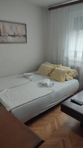 a bed sitting in a room with a table at Pozarevac-Centar-Stan in Požarevac