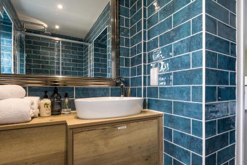 a bathroom with blue tiled walls and a sink at Kenton in Newquay