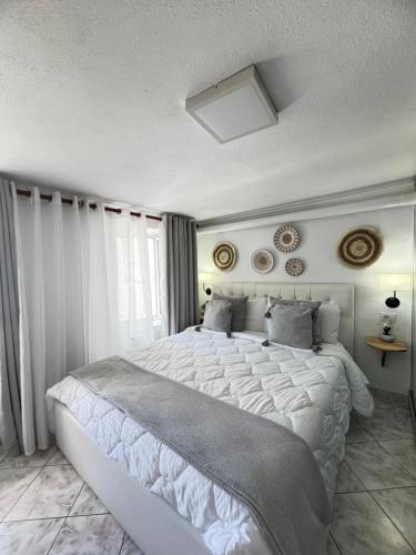 ein Schlafzimmer mit einem großen weißen Bett und einem Fenster in der Unterkunft Himalayas in Gjirokastër