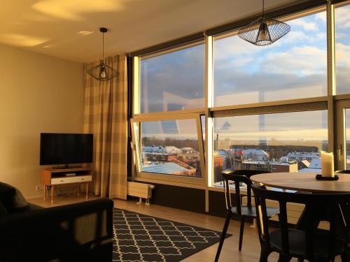sala de estar con mesa y ventana grande en City View Apartment, free parking, en Pärnu