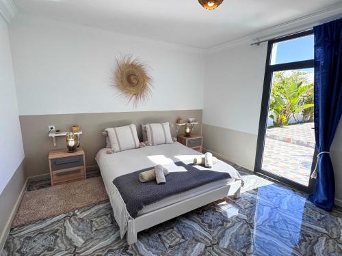 a bedroom with a bed and a large window at Villa Massalia Essaouira in Essaouira