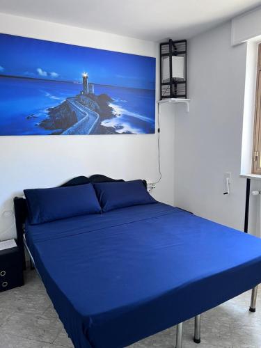 a blue bed in a room with a painting on the wall at Happy's Casa in Putignano