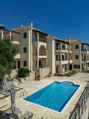 an apartment with a swimming pool in front of a building at Niriides Luxury Apartments in Syvota