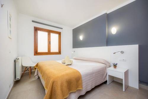 a bedroom with a bed with a yellow blanket on it at Cala Figuera Apartment 4b in Cala Figuera