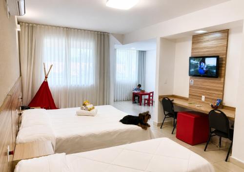 a bedroom with a large bed with a dog laying on it at Village Resort All Fun Inclusive in Jaboticatubas