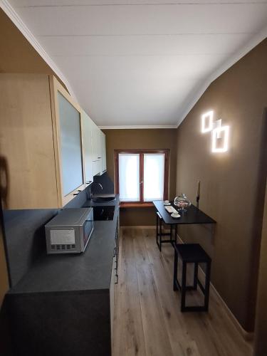 a kitchen with a counter and a table and a window at DolomitiBel Garibaldina in Belluno
