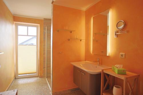 a bathroom with a sink and a mirror at Strandvilla Börgerende in Börgerende-Rethwisch