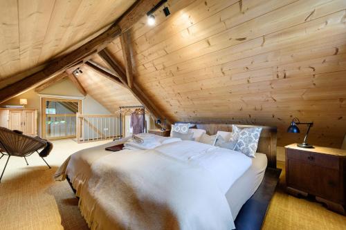 a bedroom with a large bed in a room with wooden ceilings at Hofgut Heiligenberg in Heiligenberg