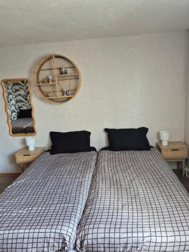 a bedroom with two beds and a mirror on the wall at Le repaire des 6 Manalas in Ingersheim