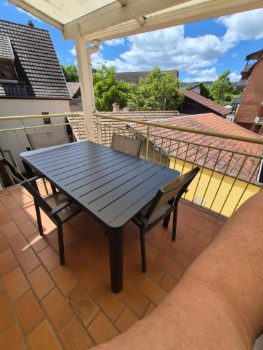 a table and chairs on a patio with a roof at Le repaire des 6 Manalas in Ingersheim