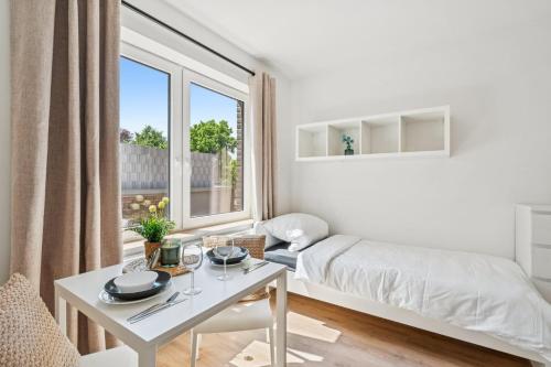 a white living room with a bed and a table at Boardinghouse Rees in Rees