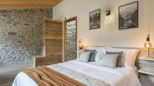 a bedroom with a bed and a stone wall at Chalet Ferrari in Ponte di Legno