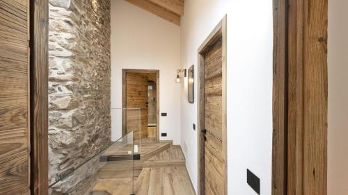 a hallway with a stone wall and a glass door at Chalet Ferrari in Ponte di Legno