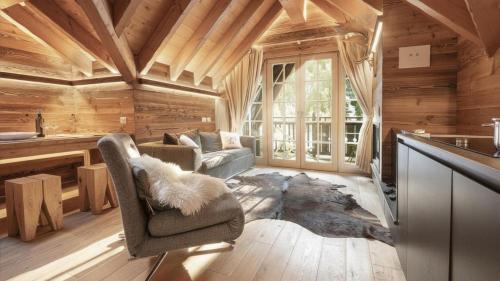 a living room with a couch and a chair in a cabin at Alpen Chalet in Ponte di Legno