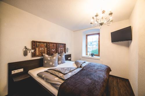 ザウテンスにあるSchneggnheisl - Appartementのベッドルーム1室(ベッド1台、壁掛けテレビ付)