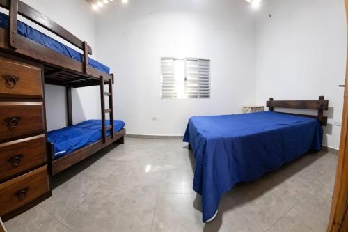 a bedroom with two bunk beds with blue sheets at Casa Ubatuba in Ubatuba