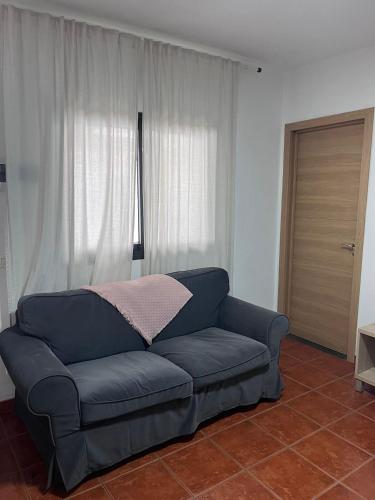 a blue couch in a living room with a window at El Isleño in Valverde