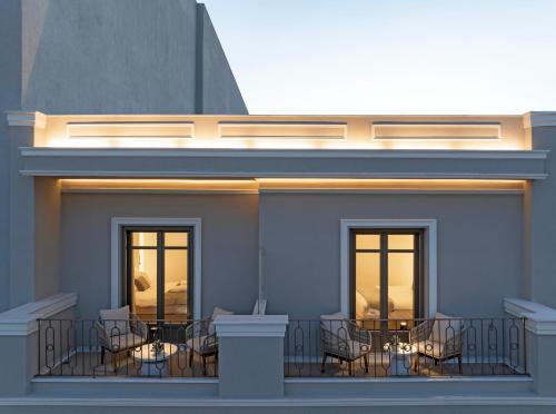 a rendering of a balcony with tables and chairs at Heronia Suites in Karistos