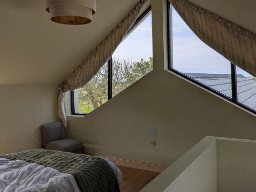 a bedroom with a bed and a large window at The Rookery in Greenfield Cross Roads