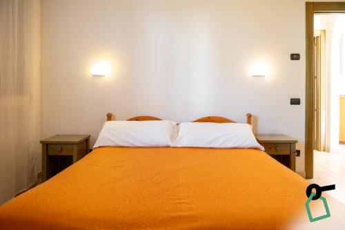 a bedroom with a bed with an orange blanket at Hotiday Gallipoli Masseria in Gallipoli