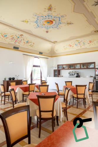a restaurant with tables and chairs and a ceiling at Hotiday Gallipoli Masseria in Gallipoli