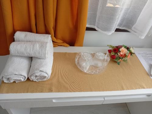 a pile of towels and flowers on a table at ASK MOUNTAIN in Buşteni
