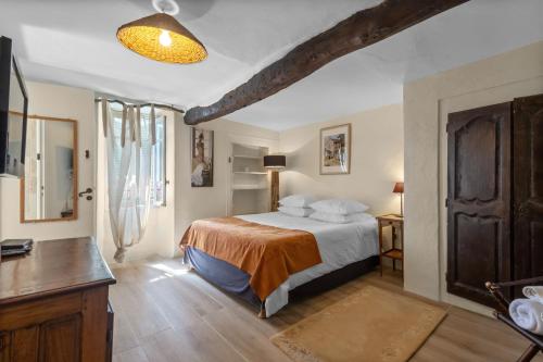 a bedroom with a large bed in a room with a table at Les Pigerolles de Cabris in Cabris