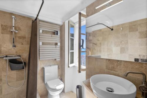 a bathroom with a white toilet and a sink at Les Pigerolles de Cabris in Cabris