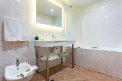 a bathroom with a sink and a toilet and a tub at Ljuljak Hotel in Golden Sands