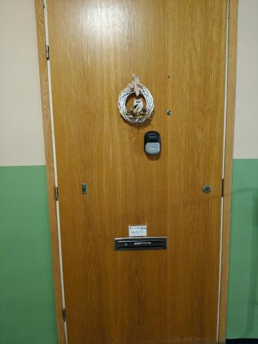 una porta di legno con un cartello sopra di Peaceful and spacious apartment with free parking a Kemi