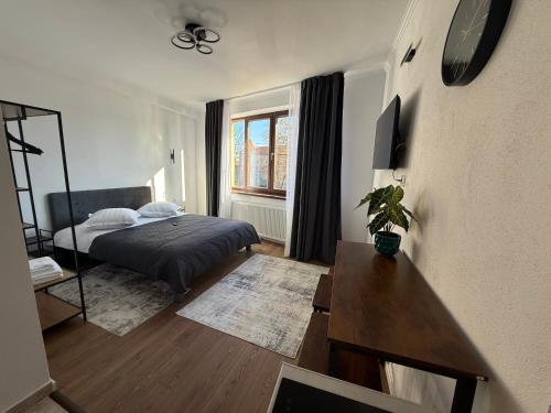 a bedroom with a bed and a table in it at Castle View Apartments in Făgăraş