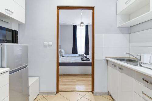 a kitchen with white cabinets and a mirror at 70s Hostel in Krakow