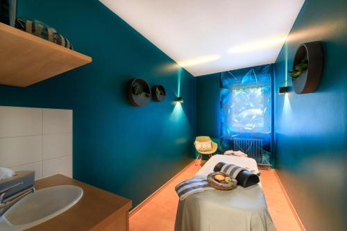 a blue bathroom with a sink and a bed at relexa hotel Bad Steben in Bad Steben