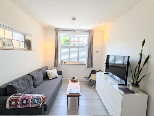 a living room with a couch and a tv at New Barnet Fresh Apartment in New Barnet