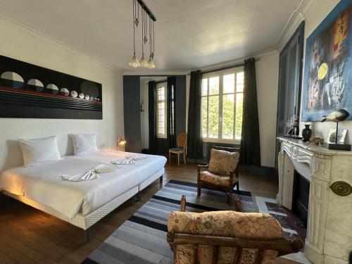 a bedroom with a large white bed and a fireplace at Logement entier hyper centre Chartres in Chartres
