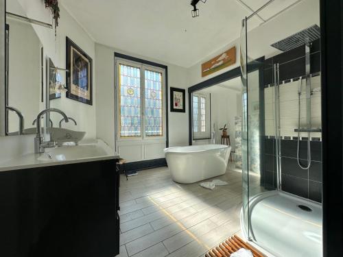 a bathroom with a tub and a sink and a shower at Logement entier hyper centre Chartres in Chartres