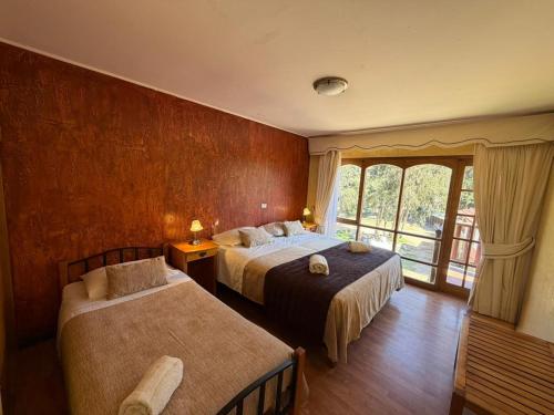 a hotel room with two beds and a window at Hotel Naturaleza Vertientes de Elqui in El Molle