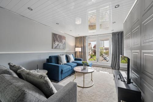 a living room with a blue couch and a table at The Glasgow Nook in Glasgow