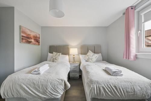 two beds sitting next to each other in a bedroom at The Glasgow Nook in Glasgow