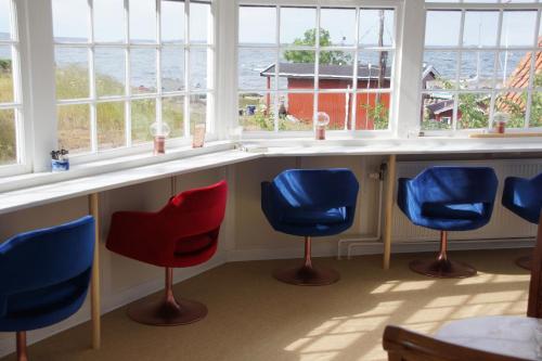 a waiting room with four chairs in front of a window at Hotel Sandvig Havn in Sandvig