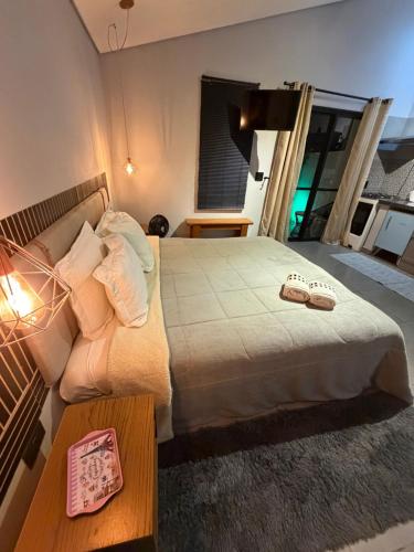 a bedroom with a bed with two slippers on it at Chalé Reserva El Paso in Mairiporã