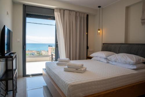 a bedroom with a bed with towels on it at Evi Seaside Suites in Kanali