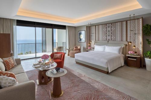 a bedroom with a bed and a living room at Mandarin Oriental, Muscat in Muscat