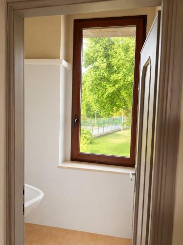 a bathroom with a window and a white tub at Charm Studio - Large private terrace, Masserano in Masserano