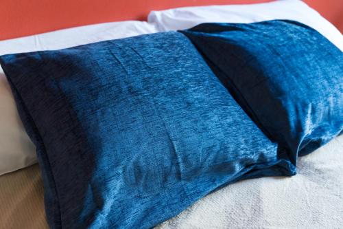a blue pillow sitting on top of a bed at VMHostel in Montecatini Terme